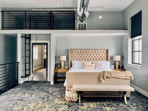 Une chambre de style industriel avec un lit double et une fenêtre