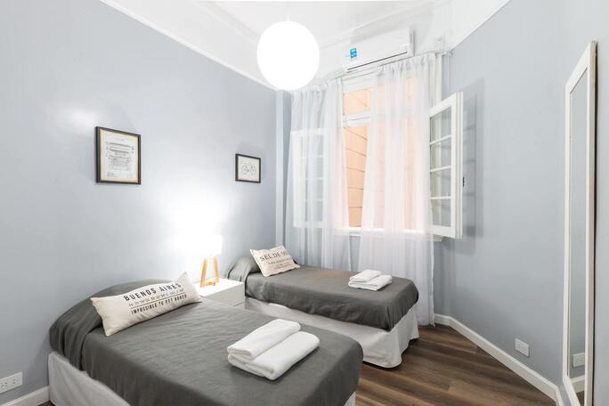 Une chambre deux lits simples avec une fenêtre