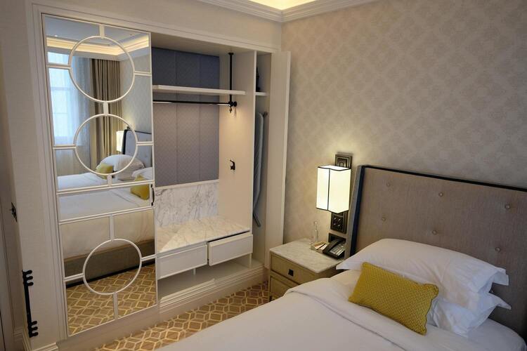 Une chambre avec un lit simple et un dressing